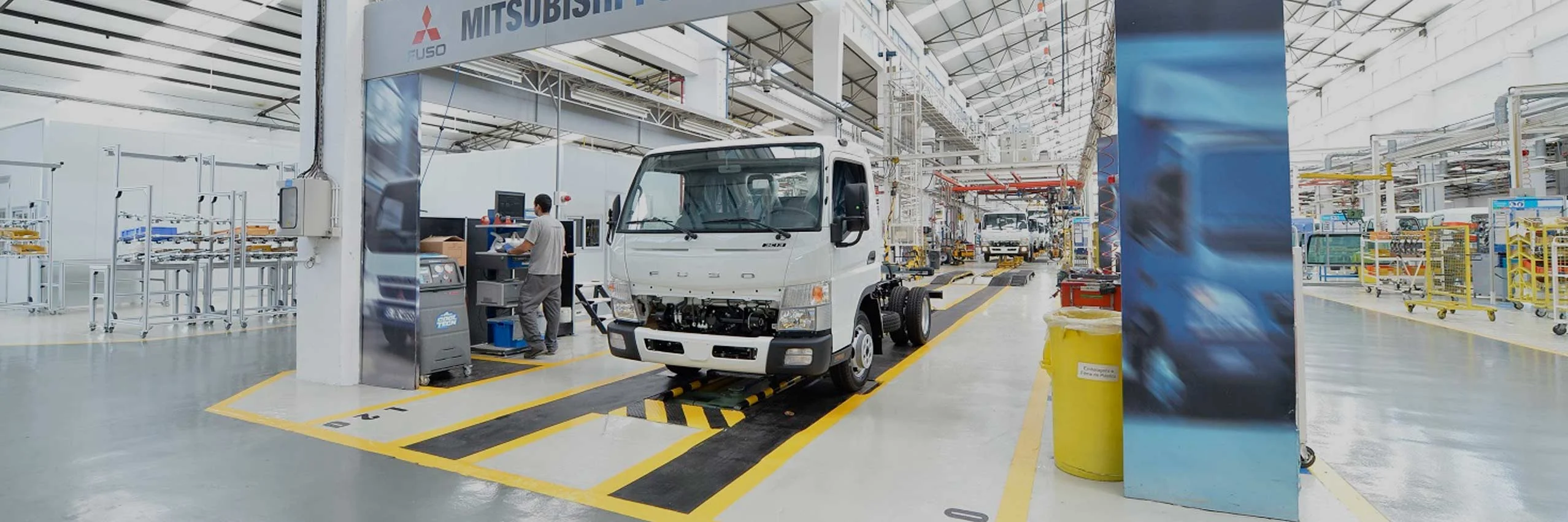 Un camion de carga FUSO Canter en un taller esperando por sus repuestos originales
